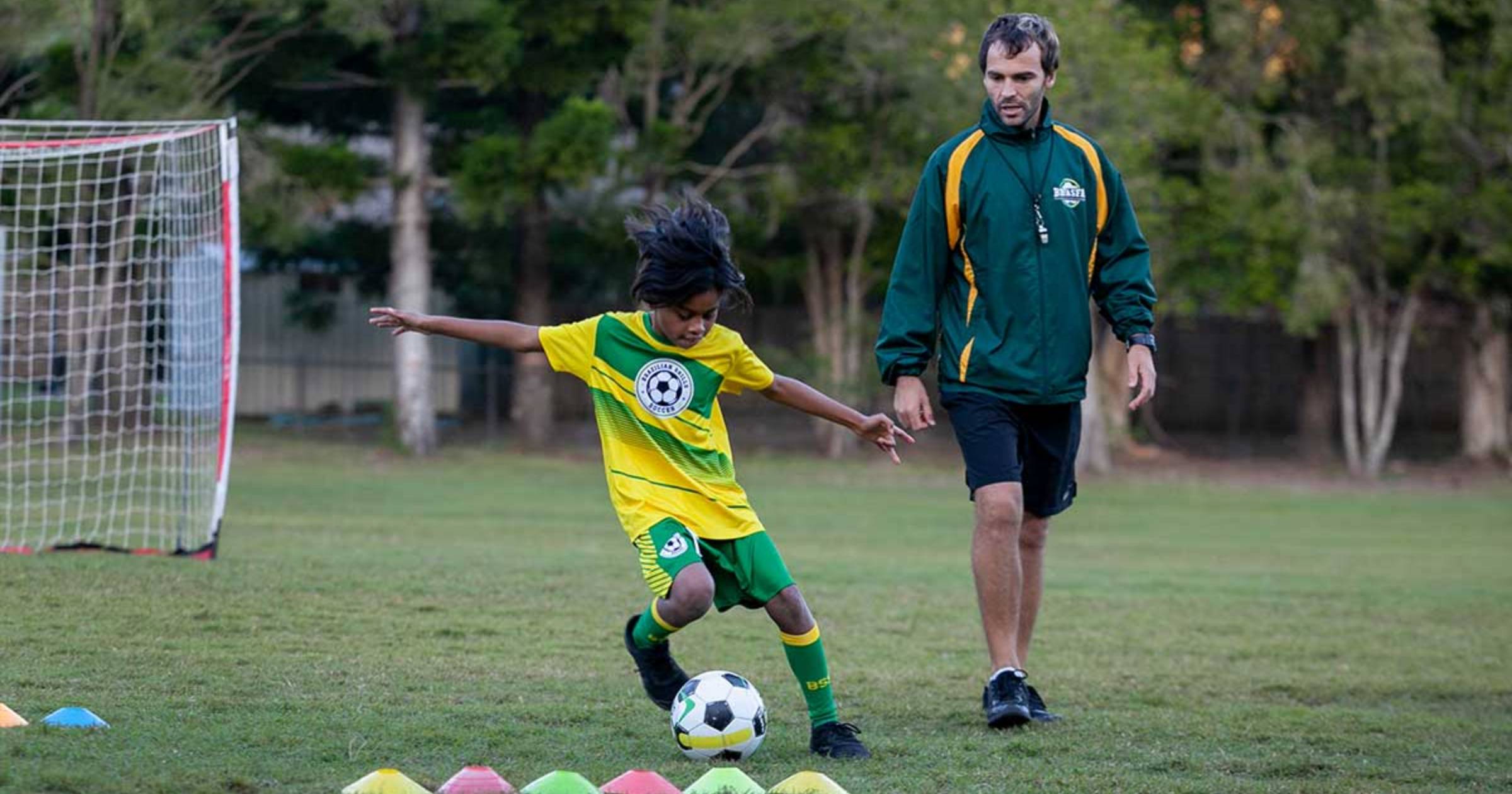 Child Playing Soccer With Coach